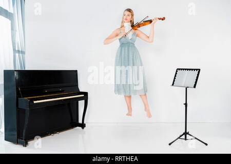 Robe fille en bleu flottant au violon et à l'écart sur fond blanc Banque D'Images