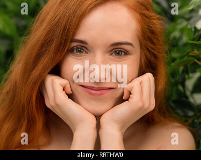 Femme pillowing redhead Curieux visage sur ses mains Banque D'Images