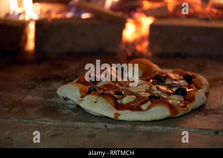 La cuisson des pizzas dans un four typique Banque D'Images