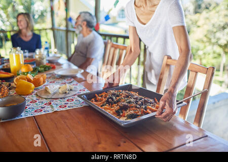 Femme de placer la nourriture sur table en hut Banque D'Images