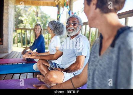 Senior man talking with woman in hut au cours de yoga retreat Banque D'Images