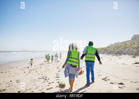 Les bénévoles le nettoyage de déchets sur la plage de sable ensoleillée Banque D'Images