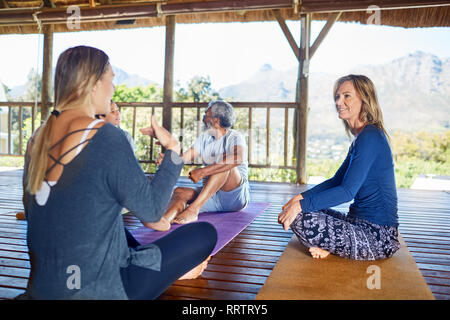 Des femmes qui parlent en hut au cours de yoga retreat Banque D'Images