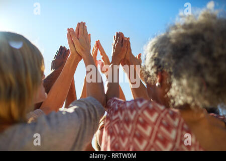 Groupe avec les mains jointes en cercle au cours de yoga retreat Banque D'Images