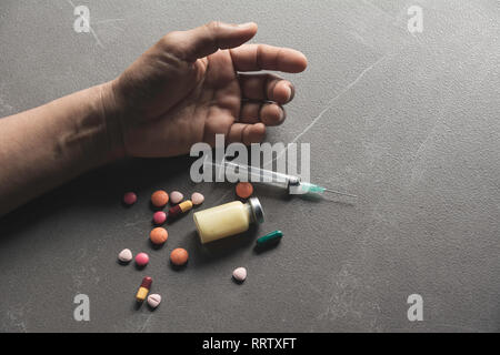 L'homme se suicide par une surdose de médicaments. Close up de surdosage comprimés et l'addict. Banque D'Images