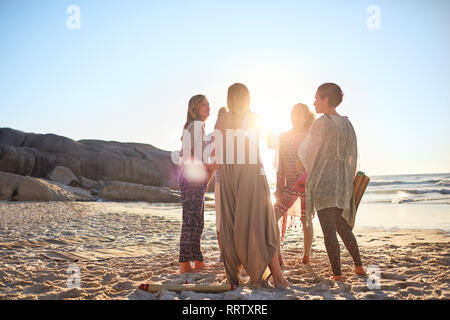 La femme debout dans le cercle à sunny beach au cours de yoga retreat Banque D'Images