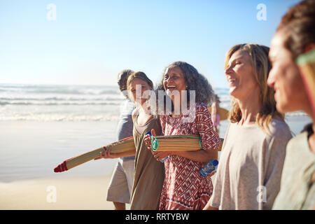 Happy friends avec tapis de yoga sur la plage ensoleillée au cours de yoga retreat Banque D'Images