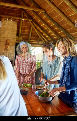 Femmes préparant repas sain dans hut au cours de yoga retreat Banque D'Images