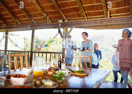 Les amis de la nourriture saine à la table dans la hutte au cours de yoga retreat Banque D'Images