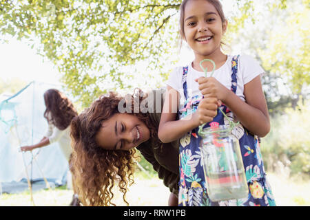 Portrait heureux soeurs la capture de poissons dans les jar Banque D'Images