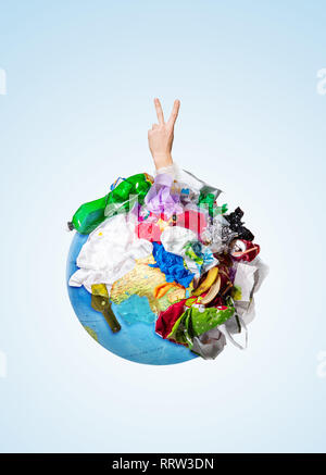 Un globe de la terre couverte d'ordures et de main d'hommes avec un geste de victoire sur fond blanc, le concept de l'écologie et la Journée mondiale de l'environnement. Photo avec un message pour publicité sociale Banque D'Images