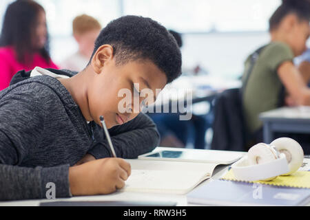 Junior high school student boy doing Homework in classroom Banque D'Images