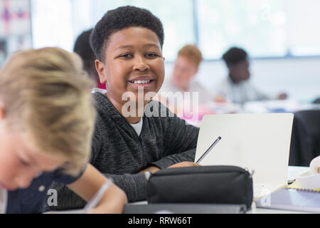 Portrait confiant junior high school boy studying in classroom Banque D'Images