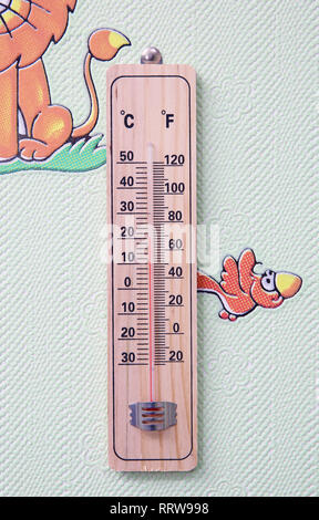 Thermomètre de météorologie isolé sur fond blanc. Thermomètre indique la température de l'air plus 50 degrés celsius . Thermomètre mural sur une fenêtre givrée. Banque D'Images