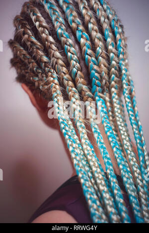 Les femmes de cornrows une femme avec une coupe sur un fond blanc, les tresses serrées dans une queue tressée, matériau artificiel tissé dans ses cheveux Banque D'Images