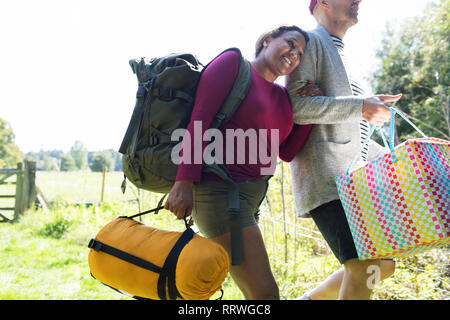 Affectionate couple transportant l'équipement de camping Banque D'Images