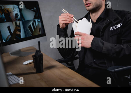 Portrait du gardien en uniforme eating junk food Banque D'Images