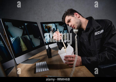 En uniforme de garde manger malbouffe et talking on telephone Banque D'Images