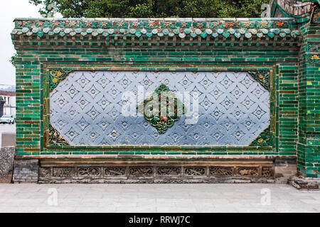 Beaux Détails Oriental chinois traditionnel sur un mur. Une clôture a fait de carreaux émaillés vert et gris. Banque D'Images