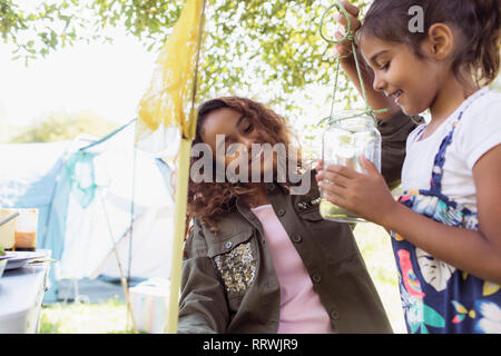 Sœurs attraper des insectes dans le bocal de camping Banque D'Images