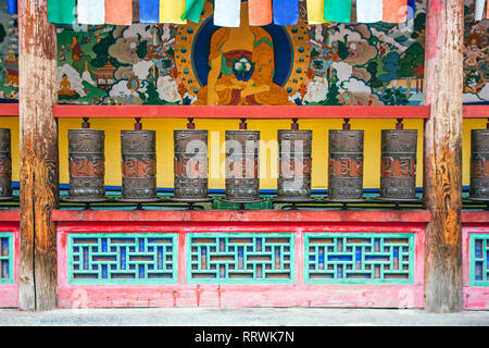 Vue orthogonale Metal grave priant les bouteilles en un temple bouddhiste de Kumbum. Façade de la rotation des éléments religieux dans un monastère tibétain. Banque D'Images