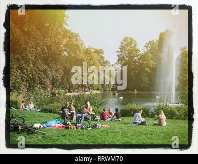 STRASBOURG, FRANCE - Sep 24, 2017 : foule de gens profiter du soleil sur une première journée d'automne à Strasbourg Orangerie parc public sur la frontière d'un lac avec une fontaine vintage Cadre de film Banque D'Images