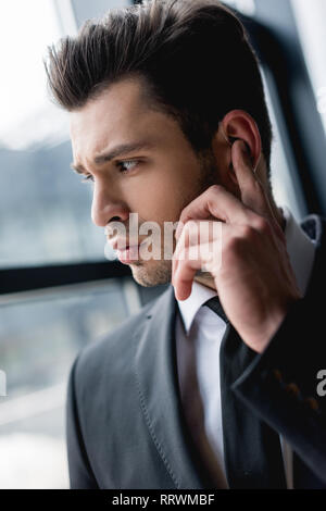 Close up of handsome garde du corps à l'aide d'écouteur Banque D'Images