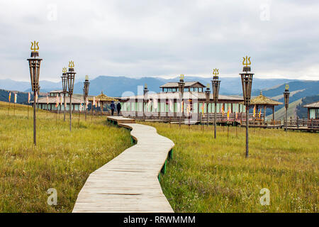 Promenade en bois au-dessus de la prairie pelouse mène un couple de personnes aux pavillons mongoles et tibétaines. Banque D'Images