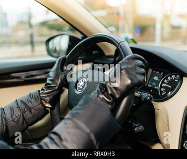 STRASBOURG, FRANCE - DEC 26, 2018 : Woman driving tchèque Skoda Octavia voiture portant des gants de cuir se concentrer sur la voiture logo sur le volant Banque D'Images