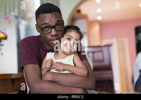 Affectueux Portrait teenage frère hugging tout-petit soeur Banque D'Images