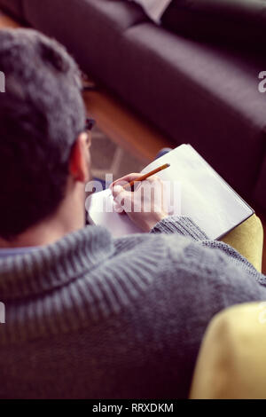 Vue de dessus d'un bel homme nice taking notes Banque D'Images