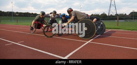 Les athlètes paraplégiques déterminé en collage, huddle formation pour les sports en fauteuil roulant sur la piste de course Banque D'Images