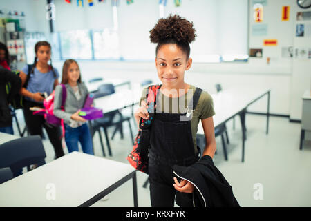 Portrait souriant, confiant junior high school girl in classroom Banque D'Images