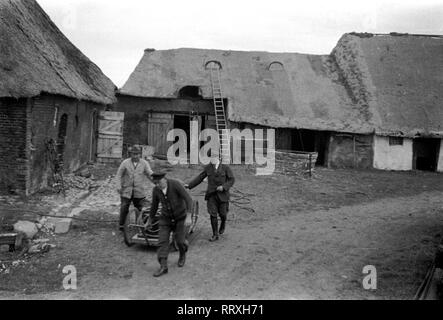 DER SCHIMMELREITER - Trois hommes transportent l'équipement de film avec un chariot à main à l'endroit du film, 10/1933, I.12/24-6 Schimmelreiter Banque D'Images