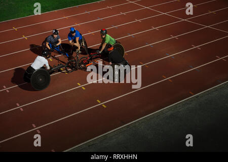 Les athlètes paraplégiques piaillent sur piste sports, course en fauteuil roulant pour la formation Banque D'Images