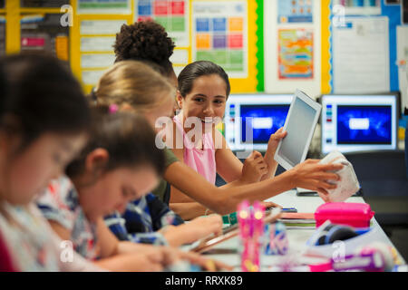 Junior High school girl étudiants using digital tablet in classroom Banque D'Images