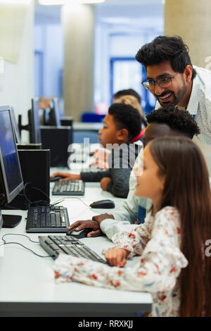 Aider les enseignants, les élèves de niveau junior à l'aide d'un ordinateur in computer lab Banque D'Images