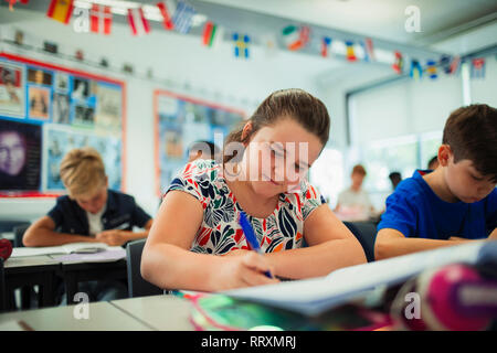 L'accent junior high school student girl doing Homework in classroom Banque D'Images