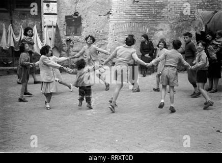 Voyage à Rome - Italie en 1950 - Les enfants dans la danse Rome ring-a-ring-a-roses dans la cour. Kinder spielen Ringelrein in einem Hinterhof en Rom, Italie. Photo Erich Andres Banque D'Images