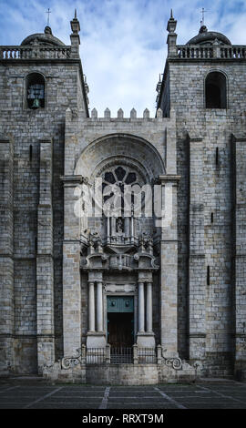 L'imposante façade de la cathédrale de Porto et sombre, contrastant avec le ciel bleu. Le célèbre Se do Porto au Portugal. Banque D'Images