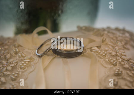 Les anneaux de mariage sur une perle robe de mariage couverte Banque D'Images
