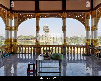 Les colonnes d'or bien décorées dans un temple bouddhiste avec la pagode de Kyauk Ka Lat sur l'arrière-plan en Hpa An, Myanmar Banque D'Images