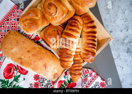 Délicieux délicieux petits pains cuits émaillés ruddy, tartes et pâtisseries à la cannelle et diverses garnitures, fabriqué à partir de farine biologique premium, disposés sur un woo Banque D'Images