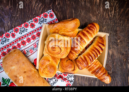 Délicieux délicieux petits pains cuits émaillés ruddy, tartes et pâtisseries à la cannelle et diverses garnitures, fabriqué à partir de farine biologique premium, disposés sur un woo Banque D'Images