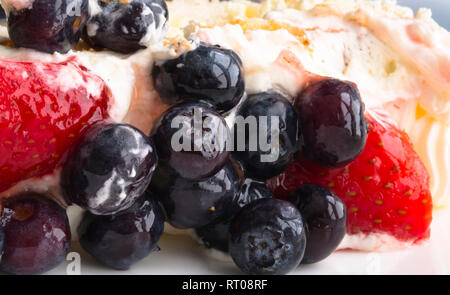 Biscuit moelleux délicieux gâteau crème au beurre assaisonné et couvert avec des bleuets frais et fraises - un dessert agréable et saine d'esprit Banque D'Images