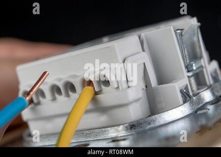 Fils électriques montés sur une prise électrique. Accessoires électriques  installés dans la chambre. Fond sombre Photo Stock - Alamy