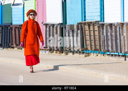 Bournemouth, Dorset, UK. Feb 27, 2019. UK météo : beau temps continue avec une autre belle chaude journée ensoleillée à Bournemouth en tant que visiteurs, profitez du soleil au bord de la mer. La plage de Bournemouth est voté la meilleure plage du Royaume-Uni. Dame en rouge bénéficie d'une promenade le long de la promenade. Credit : Carolyn Jenkins/Alamy Live News Banque D'Images