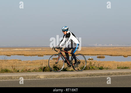 Southport, Merseyside. 27 Février, 2019. Météo britannique. Soleil voilé de commencer la journée à Marshside Réserve Naturelle, avec les cyclistes jouissant d'un sprint sur la piste cyclable Pennine Way qui donne donne généralement une bonne vue sur un ciel voilé Blackpool. La prévision est pour un autre après-midi sec et ensoleillé sur la côte nord-ouest, et la poursuite des doux. Credit : Crédit : AlamyLiveNews MWI/MediaWorldImages/Alamy Live News Banque D'Images