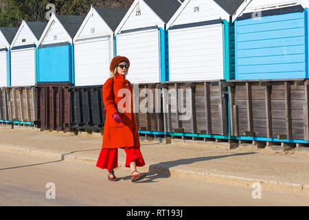 Bournemouth, Dorset, UK. Feb 27, 2019. UK météo : beau temps continue avec une autre belle chaude journée ensoleillée à Bournemouth en tant que visiteurs, profitez du soleil au bord de la mer. La plage de Bournemouth est voté la meilleure plage du Royaume-Uni. Dame en rouge bénéficie d'une promenade le long de la promenade. Credit : Carolyn Jenkins/Alamy Live News Banque D'Images