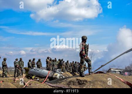 Budgam, au Cachemire. 27 Février, 2019. Les hommes de l'armée indienne recueillir près de l'épave d'un avion militaire indien qui s'est écrasé à Budgam, à 20 km de Srinagar, au Cachemire. Une armée de l'air indienne s'est écrasé mercredi dans le district de Budgam du Cachemire, tuant sept personnes dont six membres du personnel de la Force aérienne indienne et l'autre civile. L'avion s'est écrasé pour des raisons techniques, selon les responsables. Credit : Saqib Majeed/SOPA Images/ZUMA/Alamy Fil Live News Banque D'Images